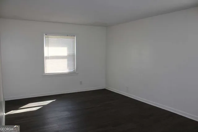 a view of a small space with wooden floor and a window