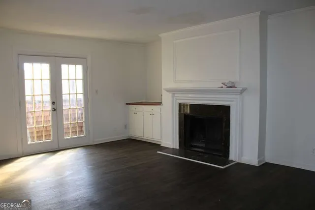 a view of empty room with wooden floor and fireplace