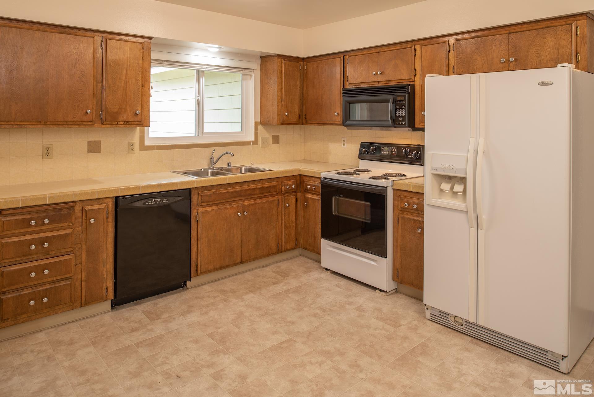 2055 Prince Way Reno, NV 89503 - Photo 7 of 35 a kitchen with stainless steel appliances granite countertop a stove a sink and a refrigerator with wooden cabinets