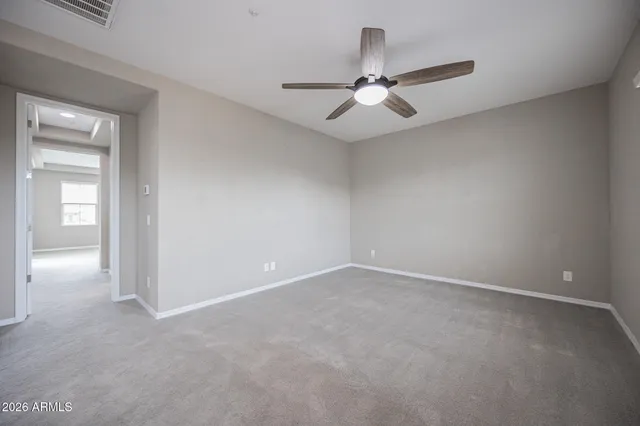 an empty room with closet and a chandelier fan