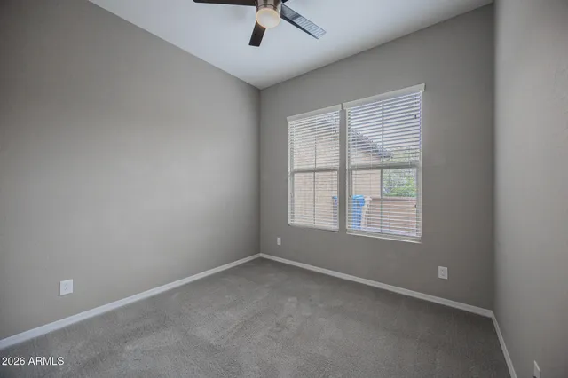 an empty room with a window and a fan