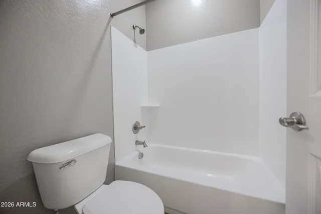 a white toilet sitting next to a bath tub