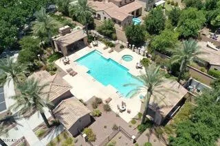 an aerial view of a house with swimming pool and large trees