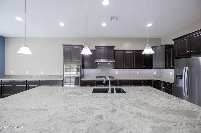 a large kitchen with a large counter top appliances and cabinets