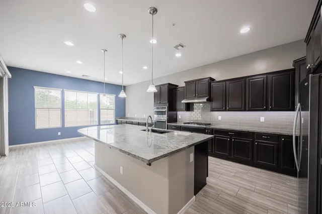 a kitchen with stainless steel appliances granite countertop a sink counter space cabinets and a large window