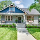 a front view of a house with a yard and potted plants