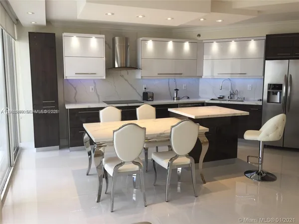 a kitchen with a table chairs refrigerator and chairs