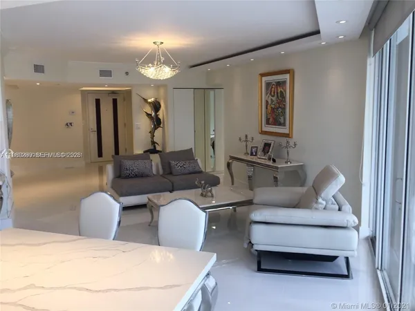 a living room with furniture a lamp and a chandelier