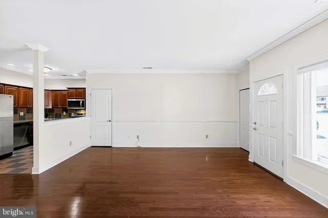 a view of empty room with wooden floor and window