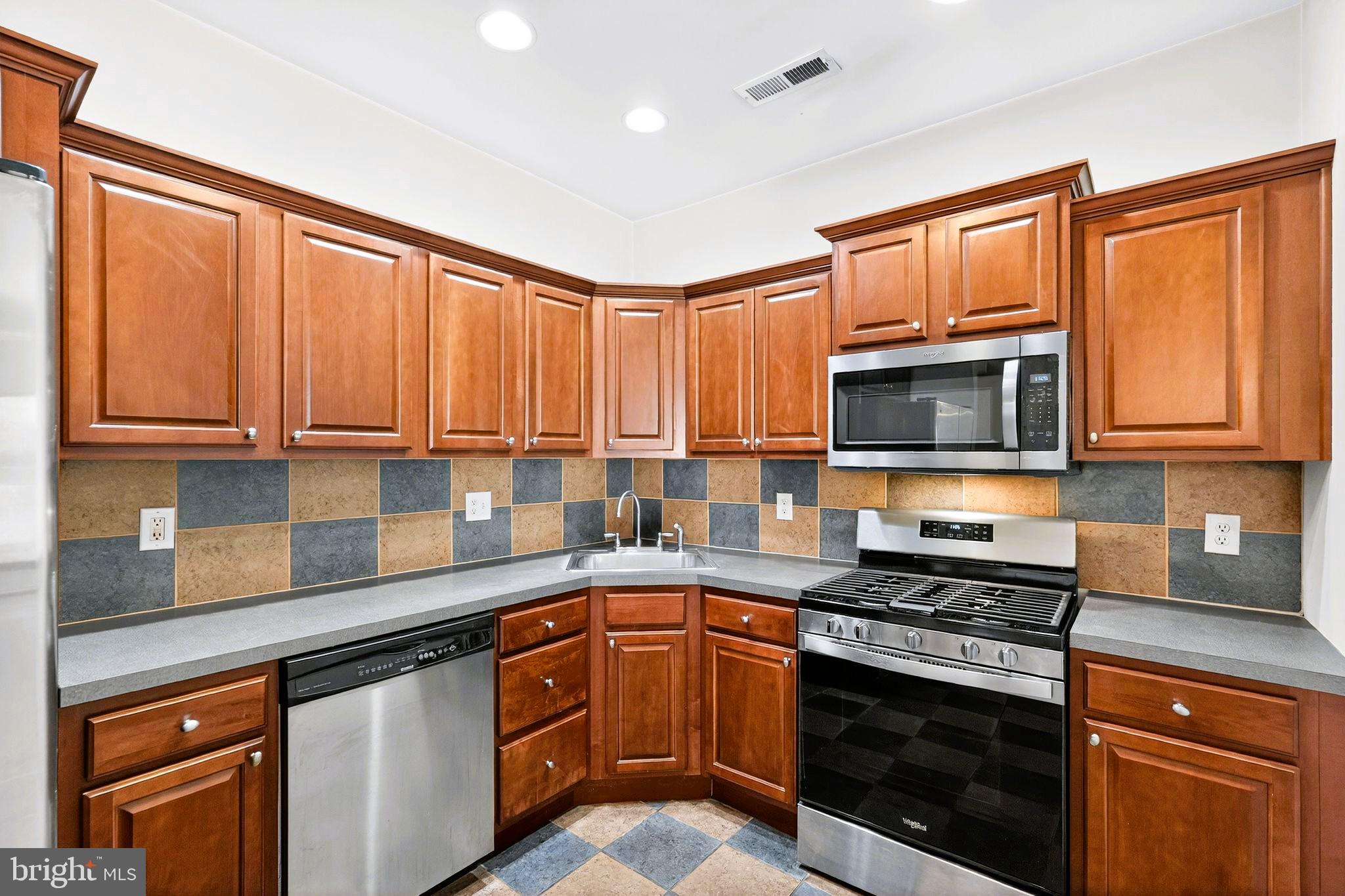 1630 Welsh Road, Unit 5A Philadelphia, PA 19115 - Photo 12 of 27 a kitchen with stainless steel appliances granite countertop a stove sink microwave and cabinets