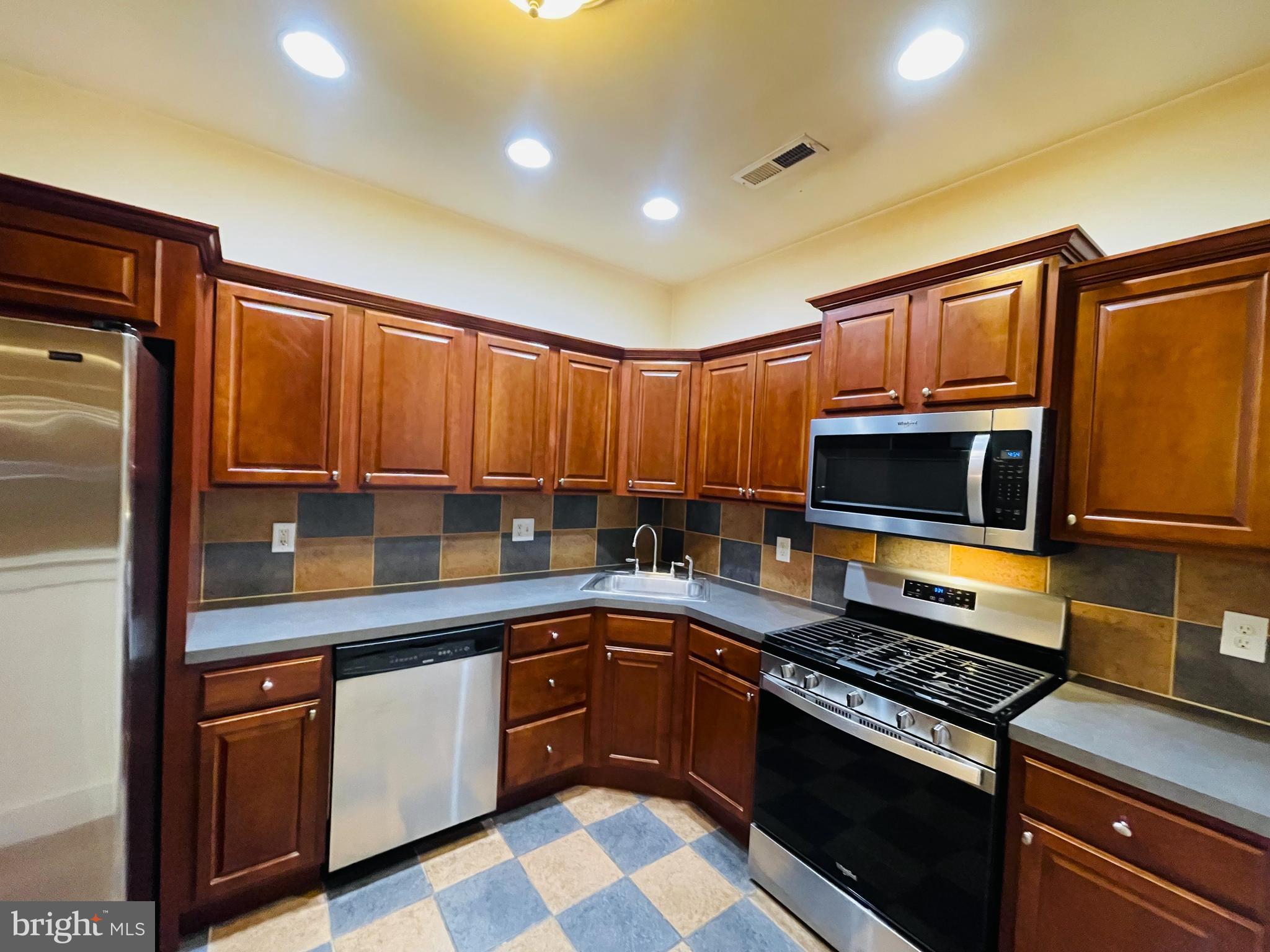 1630 Welsh Road, Unit 5A Philadelphia, PA 19115 - Photo 13 of 27 a kitchen with stainless steel appliances granite countertop a stove a sink and a microwave
