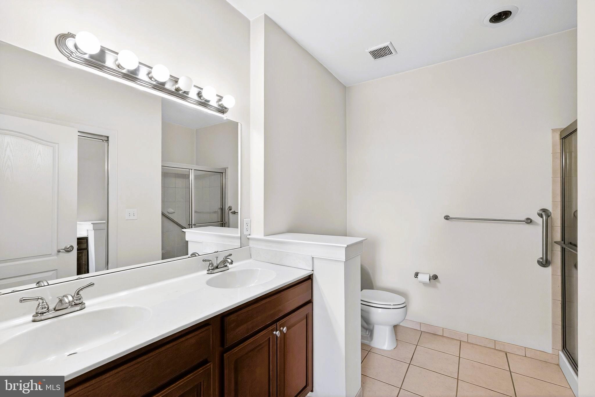 1630 Welsh Road, Unit 5A Philadelphia, PA 19115 - Photo 20 of 27 a bathroom with a sink a toilet a mirror and shower