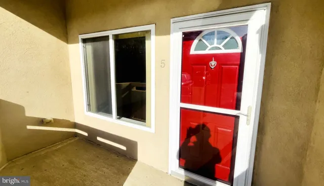 a view of a room with wooden floor and a refrigerator