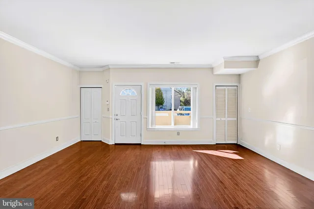 a view of a room with wooden floor and white walls