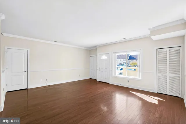 a view of a kitchen with wooden floor and stainless steel appliances