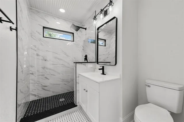 a bathroom with a toilet sink and mirror