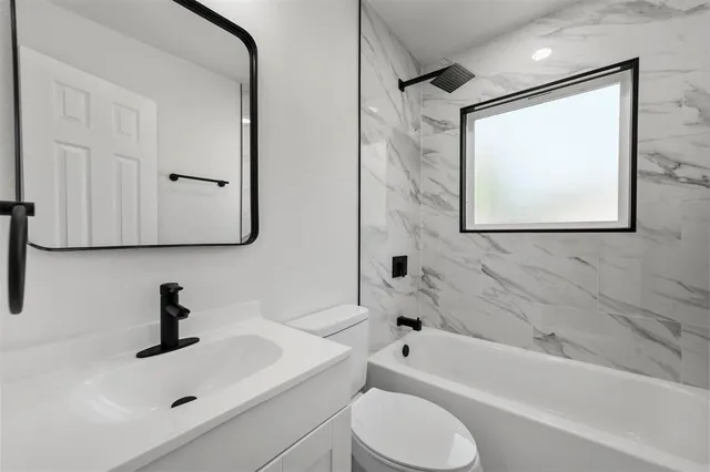 a bathroom with a sink toilet a mirror and bathtub