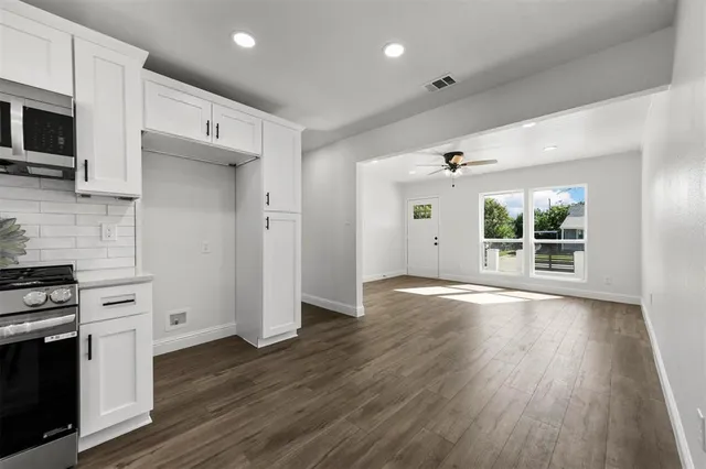 a view of a kitchen with wooden floor and electronic appliances