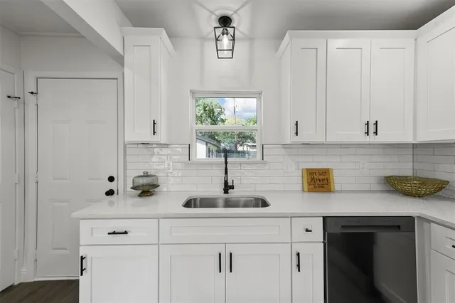 a view with cabinets a sink and wooden floor