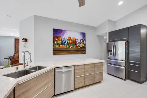 a view of a dining room with furniture one side kitchen view and wooden floor