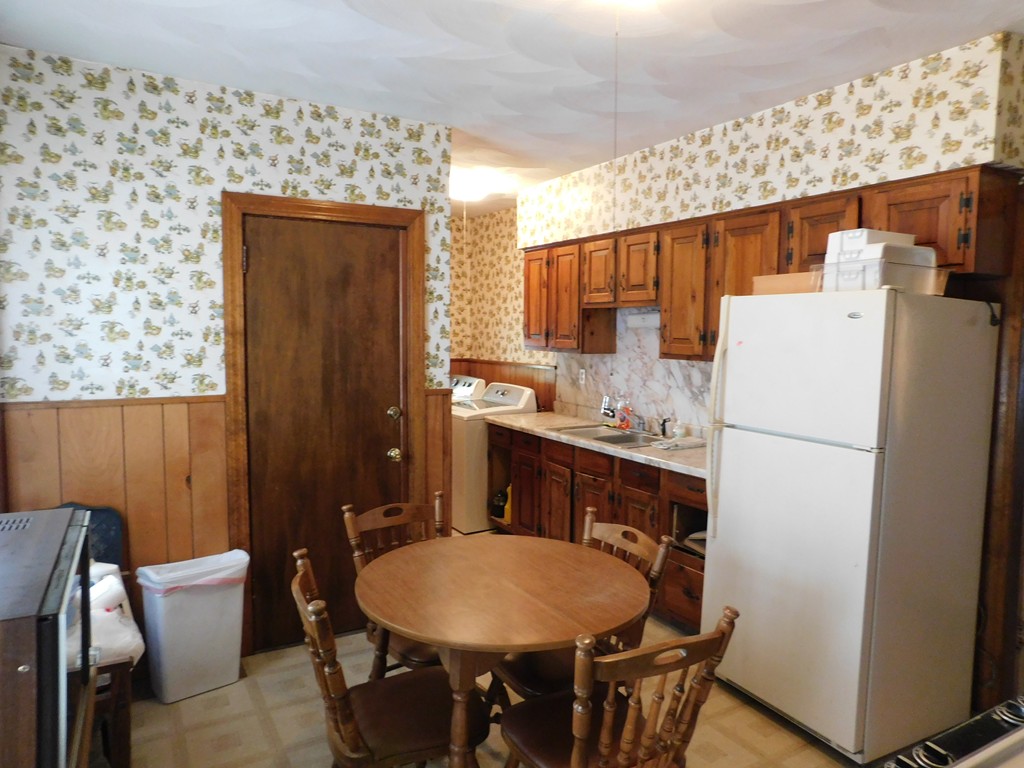 44-46 Langdon Street Springfield, MA 01104 - Photo 5 of 30 a kitchen with stainless steel appliances a refrigerator a sink a dining table and chairs