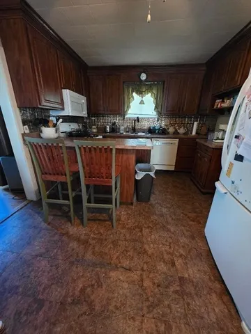 a kitchen with kitchen island granite countertop a sink a stove and a microwave