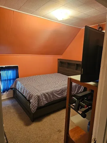 a bed sitting in a bedroom next to a window