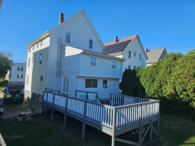 a view of a roof deck with table and chairs with wooden fence