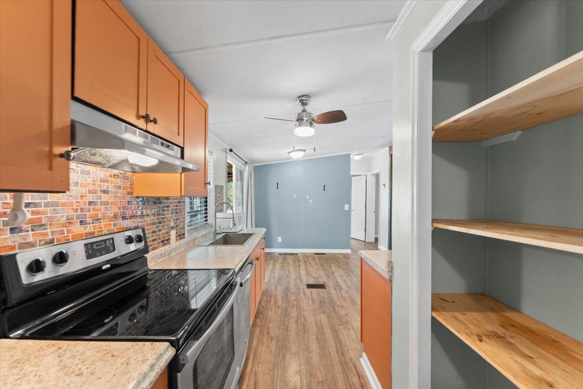 6860 Catlett Road St. Augustine, FL 32095 - Photo 11 of 36 Kitchen with stainless steel appliances, light wood finished floors, ceiling fan, light wood finish cabinets, and decorative backsplash