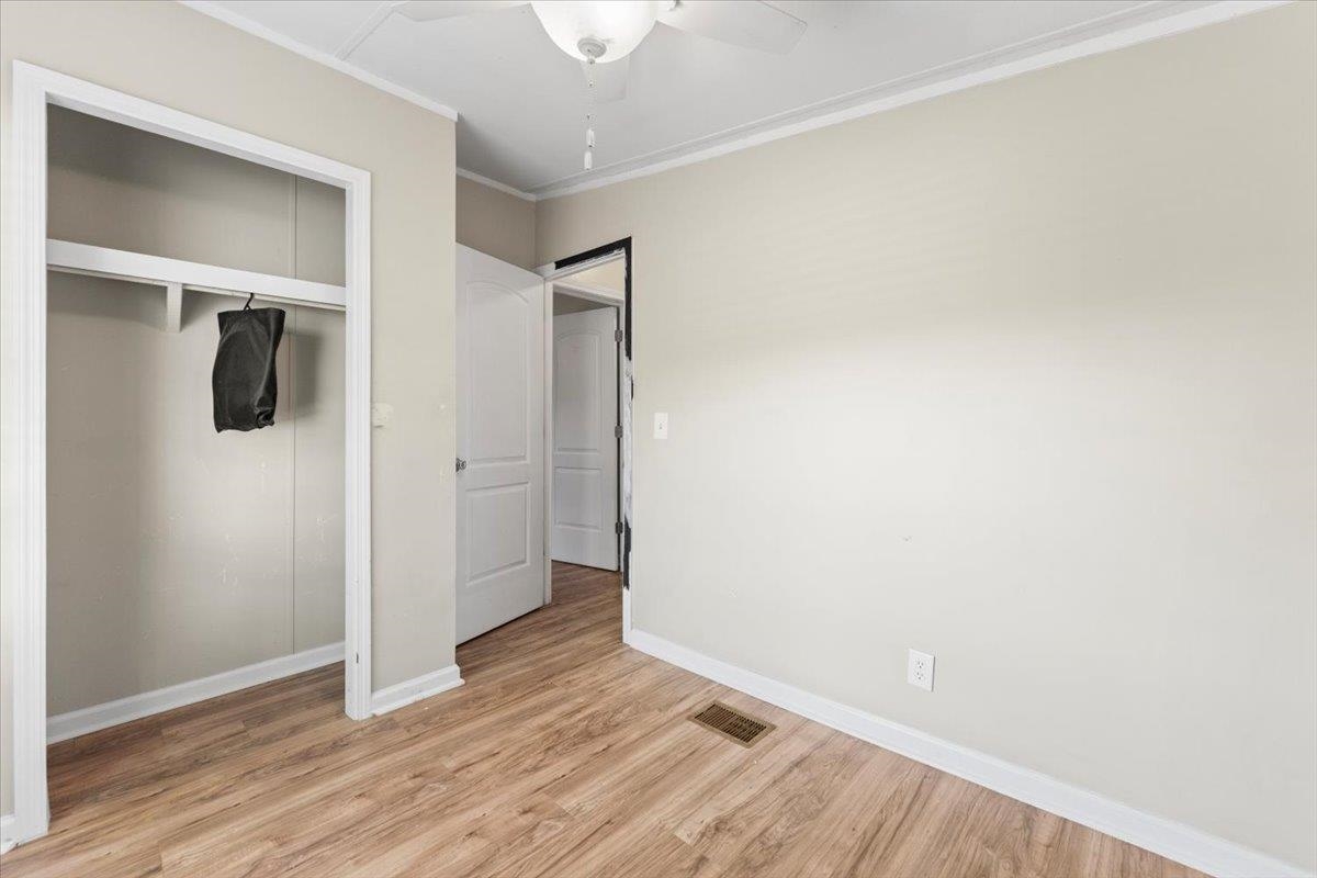 6860 Catlett Road St. Augustine, FL 32095 - Photo 16 of 36 Unfurnished bedroom with a closet, ornamental molding, light wood finished floors, and ceiling fan