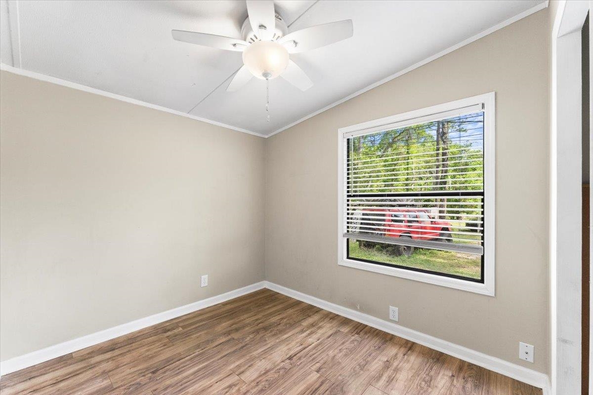 6860 Catlett Road St. Augustine, FL 32095 - Photo 17 of 36 Empty room with ornamental molding, a ceiling fan, wood finished floors, and lofted ceiling