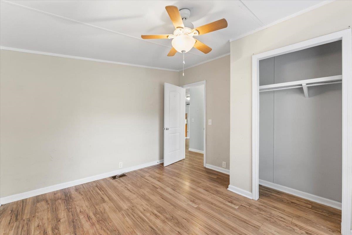 6860 Catlett Road St. Augustine, FL 32095 - Photo 19 of 36 Unfurnished bedroom featuring ornamental molding, light wood finished floors, a closet, and ceiling fan