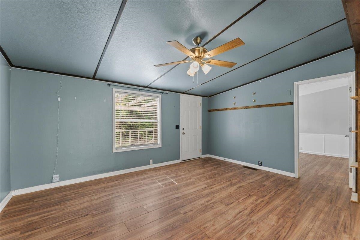 6860 Catlett Road St. Augustine, FL 32095 - Photo 4 of 36 Empty room featuring wood finished floors, vaulted ceiling, and ceiling fan