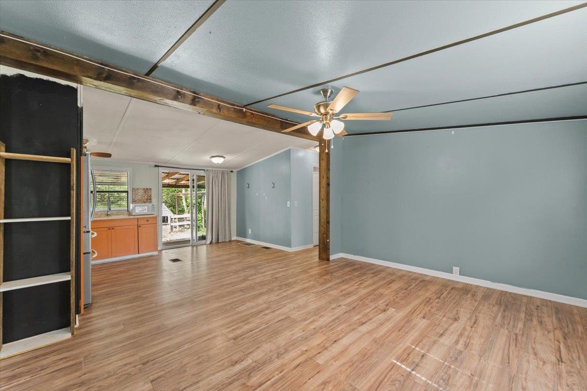 6860 Catlett Road St. Augustine, FL 32095 - Photo 6 of 36 Unfurnished living room with vaulted ceiling with beams, ceiling fan, and light wood-style flooring