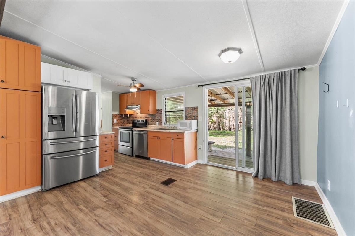 6860 Catlett Road St. Augustine, FL 32095 - Photo 8 of 36 Kitchen featuring stainless steel appliances, dark wood-style flooring, tasteful backsplash, and a ceiling fan