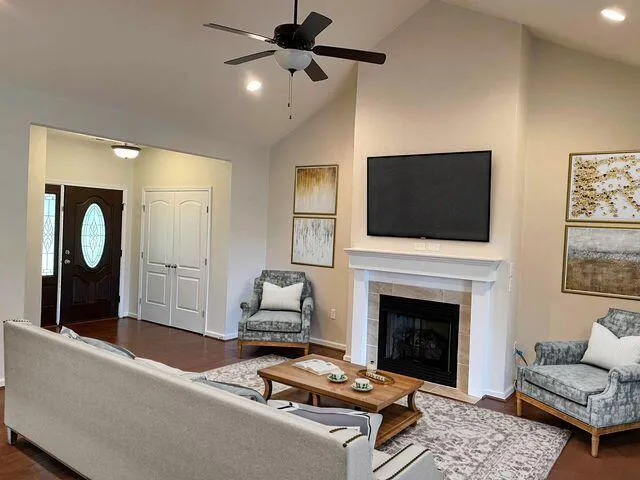 a living room with furniture a flat screen tv and a fireplace