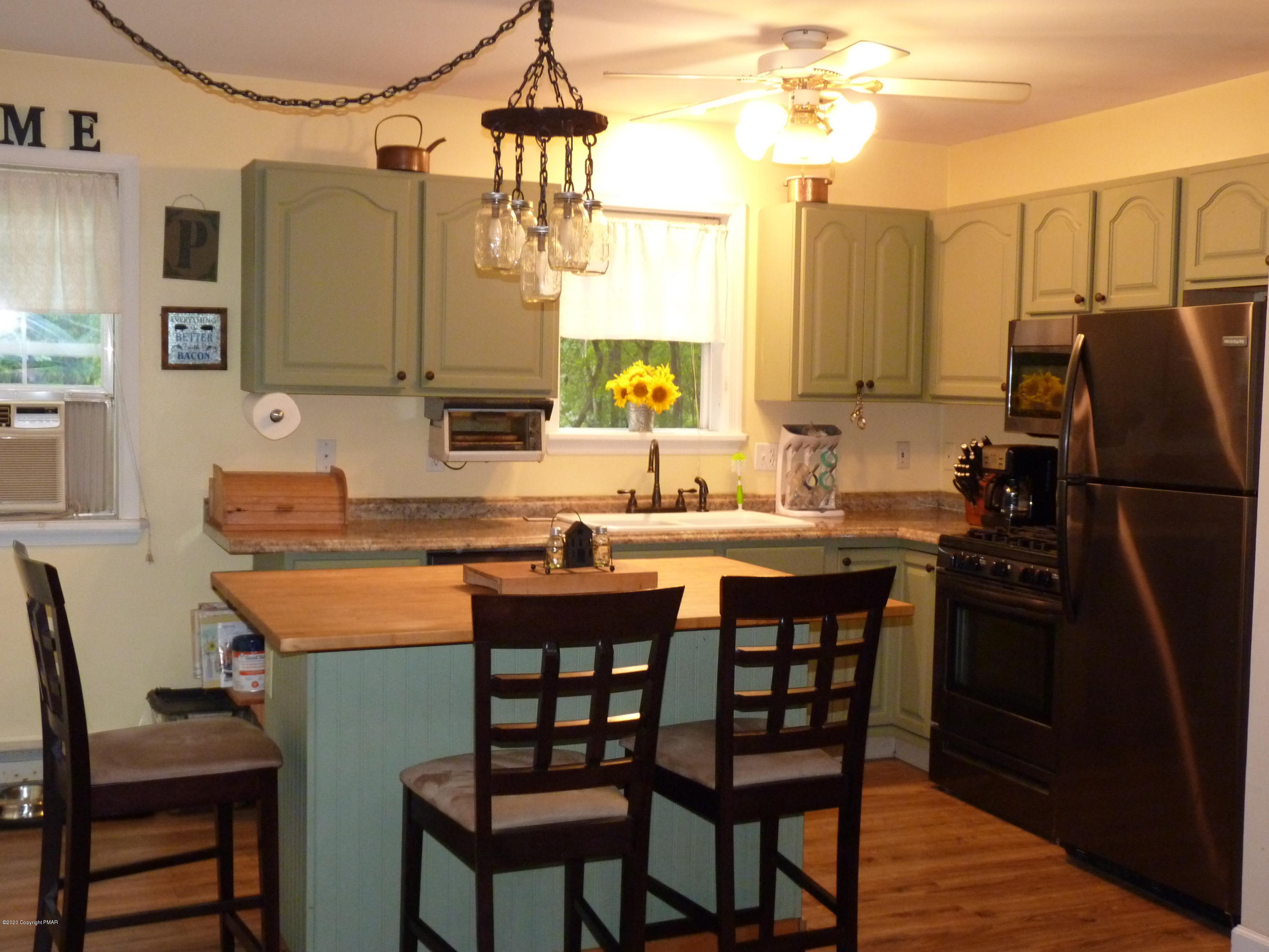 139 Fern Ridge Road Blakeslee, PA 18610 - Photo 8 of 19 a kitchen with a table chairs refrigerator and cabinets