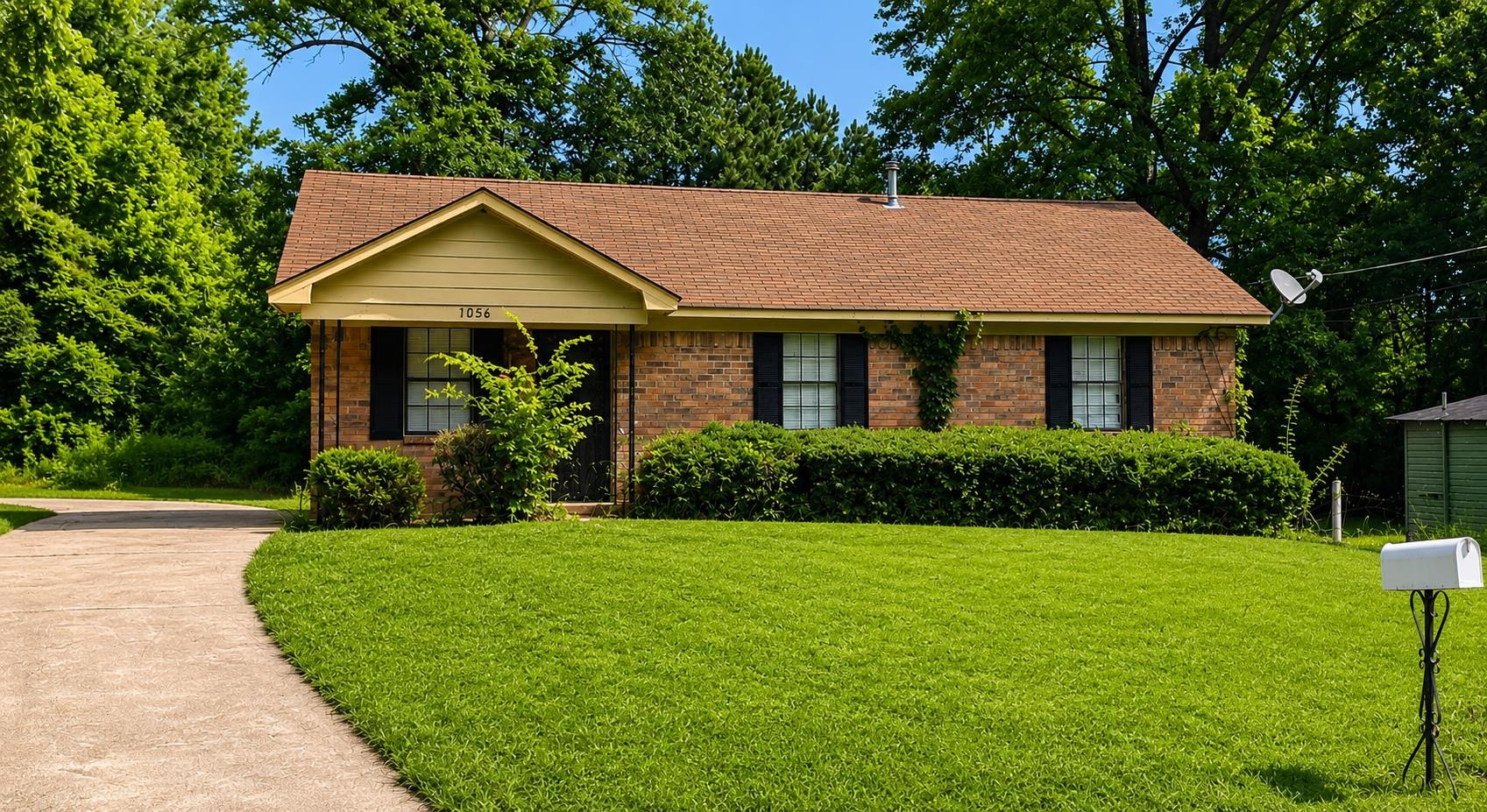 1056 Walk Road Memphis, TN 38109 - Photo 1 of 2 a front view of a house with yard and green space