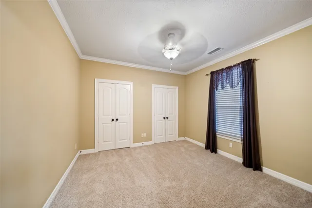 a view of room with windows and ceiling fan