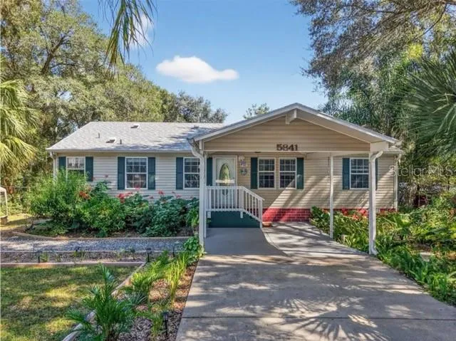 a front view of a house with swimming pool and porch with furniture