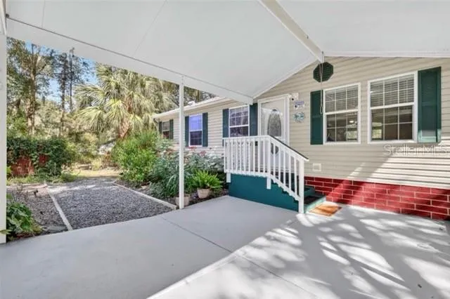 a view of a house with a small yard and wooden fence