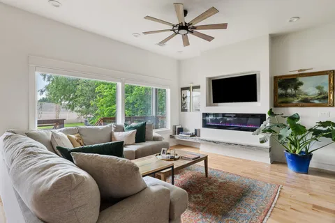 a living room with furniture a flat screen tv and a large window
