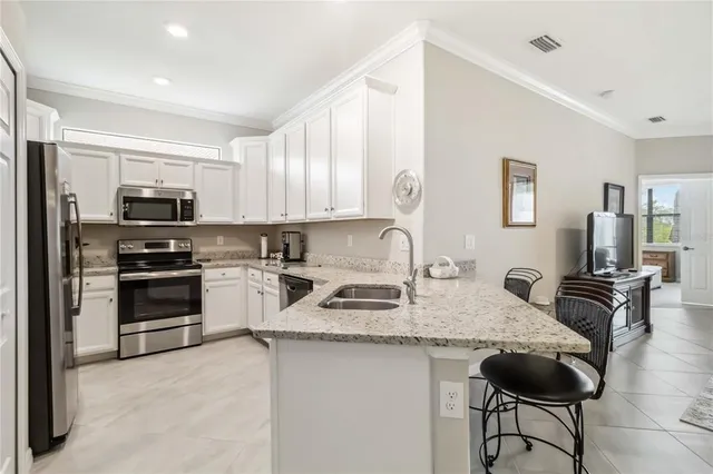 a kitchen with granite countertop cabinets a table and chairs in it