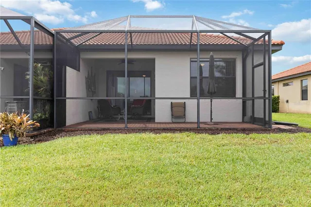 a view of a swimming pool with lawn chairs and a yard