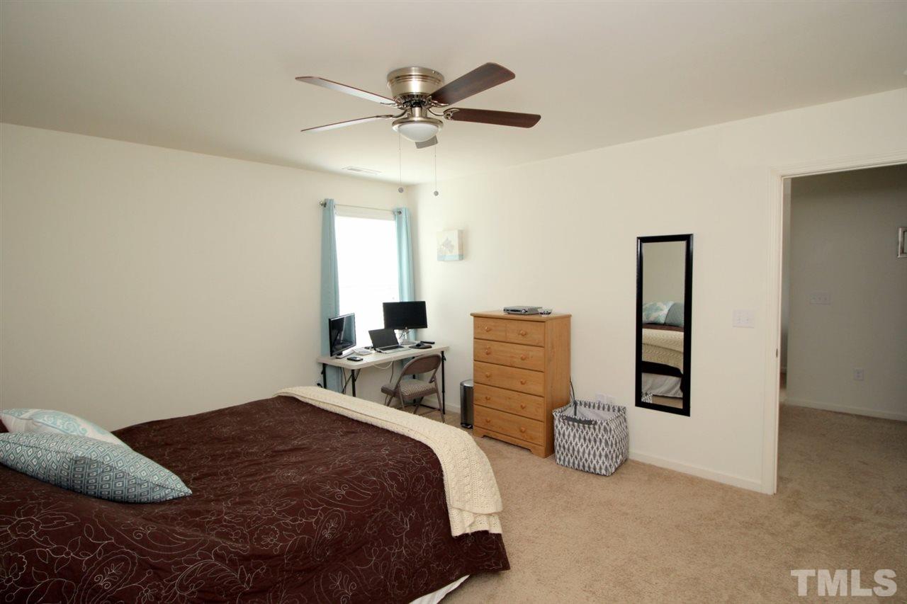 3600 Marble Ridge Lane Raleigh, NC 27610 - Photo 14 of 23 a bedroom with a bed and a chandelier