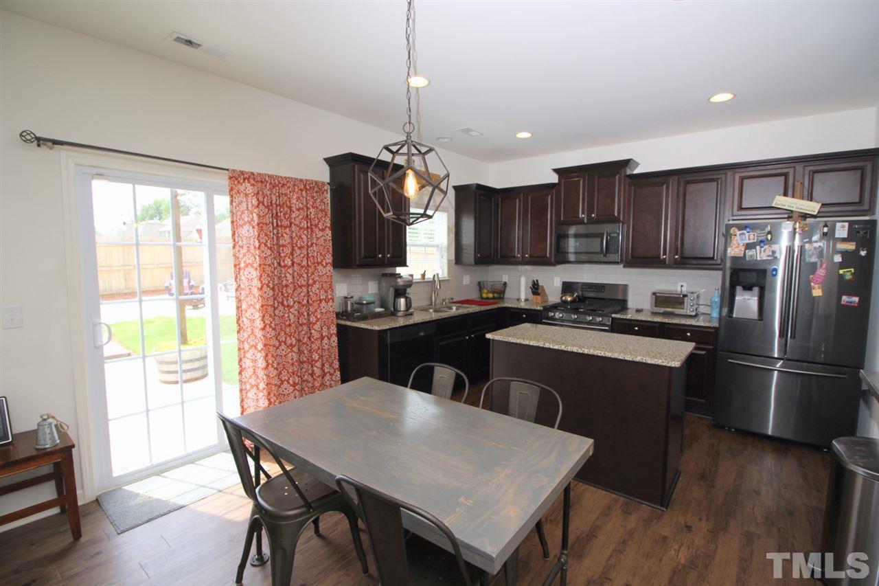 3600 Marble Ridge Lane Raleigh, NC 27610 - Photo 4 of 23 a kitchen with refrigerator a stove dining table and chairs