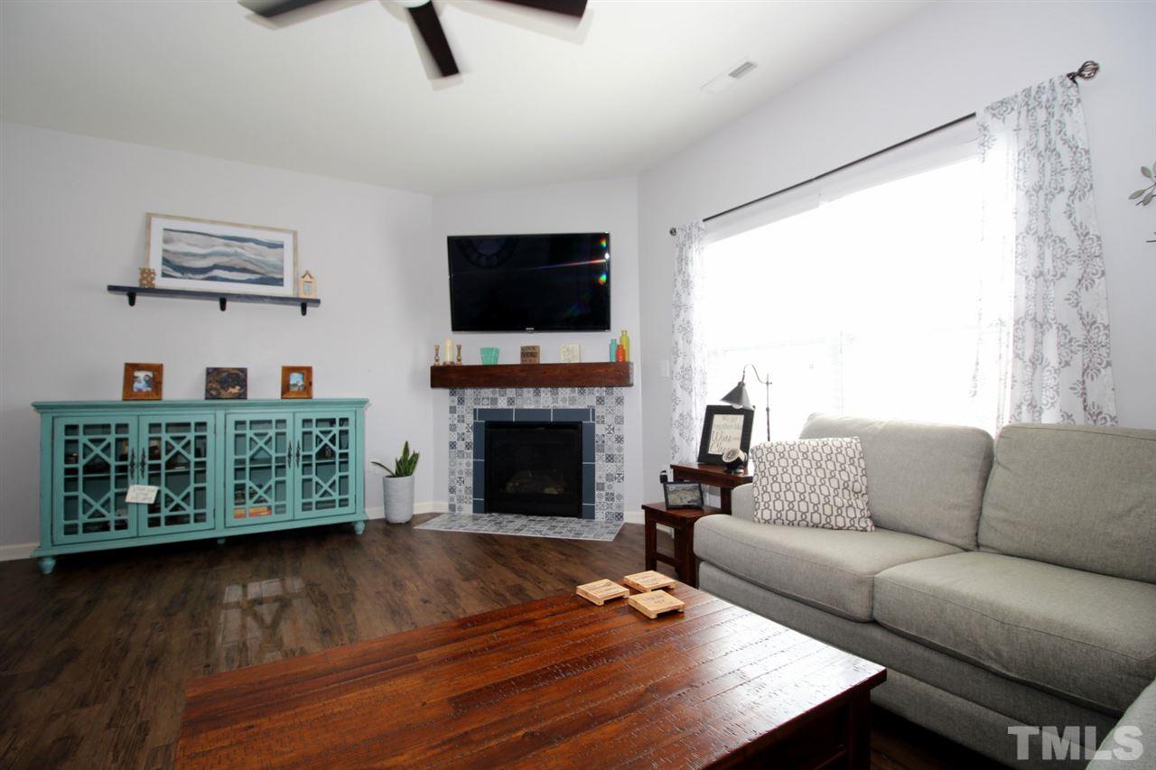 3600 Marble Ridge Lane Raleigh, NC 27610 - Photo 8 of 23 a living room with furniture a flat screen tv and a fireplace