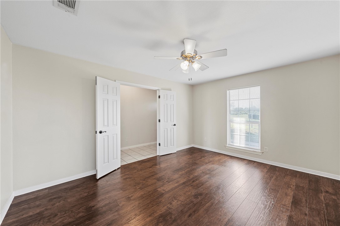 1312 North Rock Creek Road Waco, TX 76708 - Photo 21 of 46 an empty room with wooden floor and window