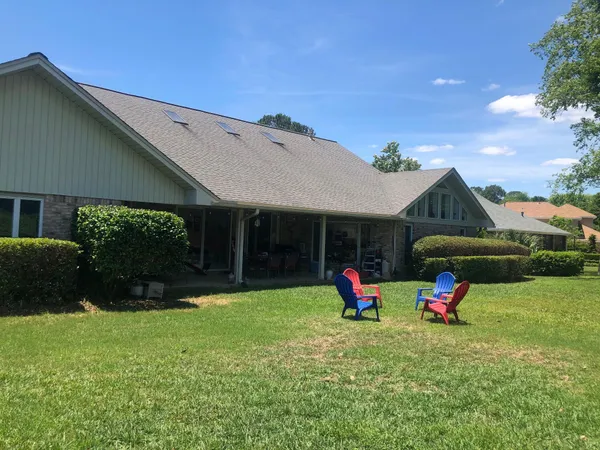 a backyard of a house with table and chairs and potted plants