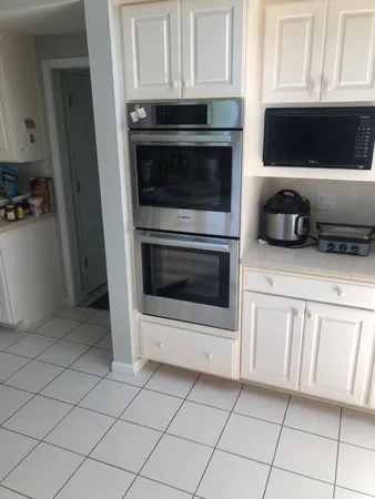 a kitchen with white cabinets and stainless steel appliances